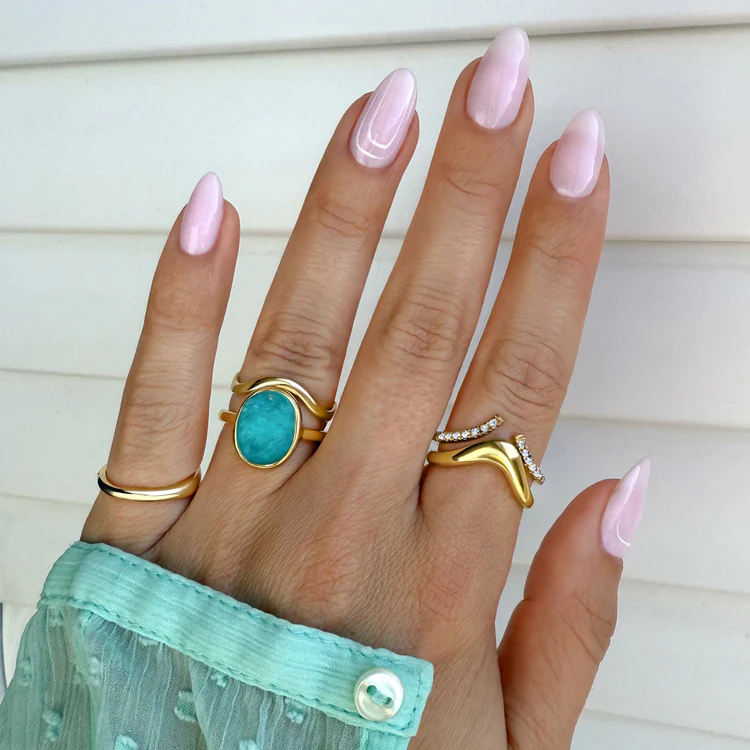 Hand wearing the CozyPetra Amazonite Harmony Ring stacked with gold bands